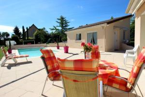 une terrasse avec une table, des chaises et une piscine dans l'établissement Les carpes a limoges, à Limoges