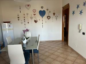 comedor con mesa y corazones en la pared en Il Focolare Casa Vacanza, en Torchiarolo