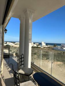 a balcony with chairs and a view of the beach at Luxury 3 Bedrooms Apartment Sea View in Rejiche