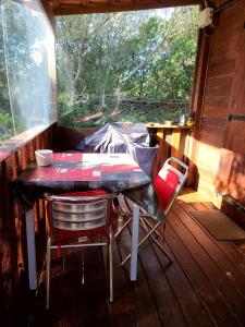 a table and chairs in a screened in porch at chalet Bati in Bonifacio +8 photos