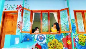 Dos muñecas mirando por la ventana de una casa de juegos en Ben Guesthouse Phu Quoc, en Phu Quoc