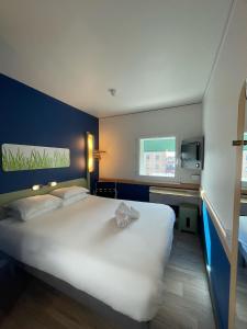 Cette chambre comprend un grand lit blanc et une fenêtre. dans l'établissement ETAP Hotel Belfast, à Belfast