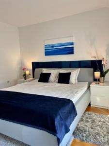 um quarto com uma cama grande e uma cabeceira azul em Apartments Corina em Zagreb