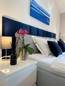 a bed with a vase with flowers on a table at Apartments Corina in Zagreb