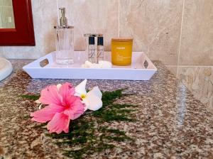 Un baño con una encimera con dos flores. en Badamier Self-Catering en La Digue
