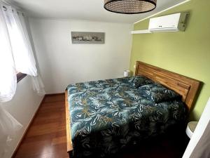 - une chambre avec un lit et une couette bleue dans l'établissement Ti Kaz Passion, à Saint-Pierre