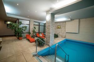 巴亚斯普列秘密花园酒店的一座带橙色椅子的建筑中的游泳池