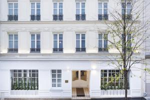 a white facade of a building with windows at Le Nest by Sweett in Paris +14 photos