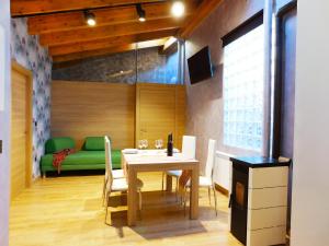 a dining room with a table and a green couch at Apartamento Ribera del Duero Reserva in Tubilla del Lago