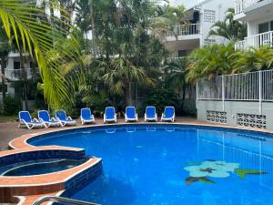 a swimming pool with lounge chairs and a hotel at Cascade Gardens Apartments in Gold Coast