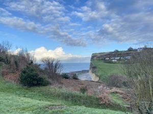 una vista del océano desde una colina con el océano en Le Manoir by CauxCottes en Vattetot-sur-Mer