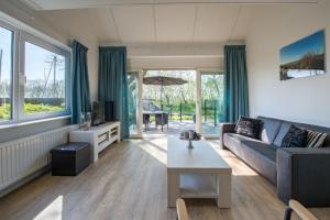 a living room with a couch and a table at Hansa watersport & recreatie in Wilhelminadorp