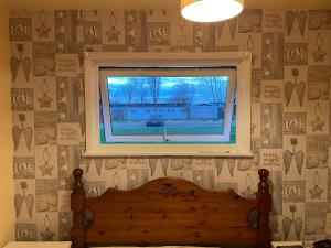 a bedroom with a window and a bed and a bed sqor at Chalet 88 in Hemsby