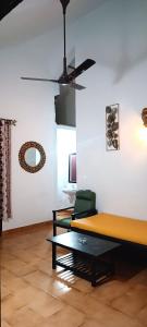 uma sala de estar com um sofá e uma ventoinha de tecto em Lairai's Happy Home em Candolim