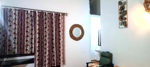 um quarto com uma cortina de chuveiro e um espelho em Lairai's Happy Home em Candolim
