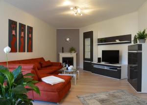 a living room with a red couch and a fireplace at AMF Ferienwohnungen historischer Soutyhof in Saarlouis