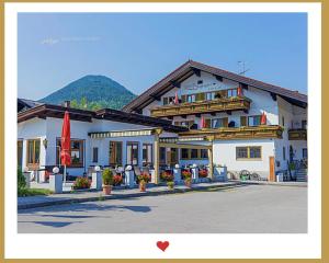 a large white building with mountains in the background at Berghupferl - do legst di nieda in Oberaudorf