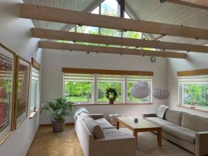 a living room with a couch and a table at Holiday Home BÅSTAD Sunday to Sunday 2 in Båstad