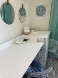 un mostrador blanco con dos espejos y una silla en Stylowy pokój dla dwojga w zacisznej okolicy en Sopot