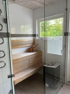 a bathroom with a shower with a bench and a window at Holiday Home BÅSTAD Sunday to Sunday 2 in Båstad +22 photos