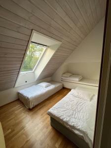 een slaapkamer op zolder met 2 bedden en een raam bij Lugn och lummig oas för den stora familjen, söndag -söndag in Båstad
