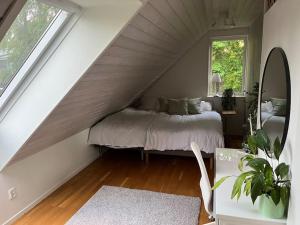 een slaapkamer met een bed op zolder bij Lugn och lummig oas för den stora familjen, söndag -söndag in Båstad