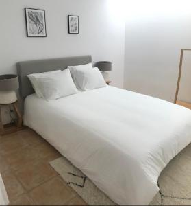 a large white bed with white sheets and pillows at Accommodation in Sesimbra - Two Double Bedroom in Sesimbra