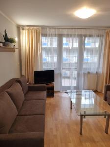 uma sala de estar com um sofá e uma mesa de vidro em Apartament Cafe Del Mar em Świnoujście