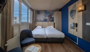 a hotel room with a bed and a chair at Fletcher Hotel Restaurant Zeeduin in Wijk aan Zee
