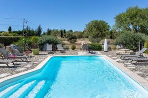 a swimming pool in a yard with chairs and a table at Gîte Coquelicot in Gargas