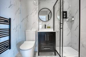 een badkamer met een toilet, een wastafel en een spiegel bij Stylish Apartment Perfect for Business or Staycation in Birmingham