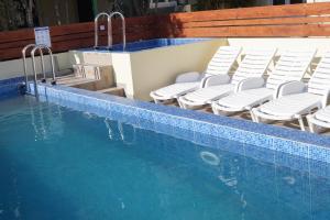 a swimming pool with chairs and a swimming pool at Studio Apartments Marija with private parking in Makarska