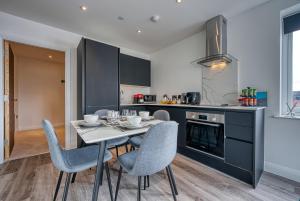een keuken met een tafel en stoelen in een kamer bij Stylish Apartment Perfect for Business or Staycation in Birmingham