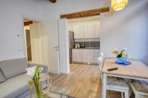 Ecco Suites Apartments في البندقية: غرفة معيشة ومطبخ مع طاولة وأريكة