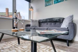 een woonkamer met een bank en een glazen tafel bij Stylish Apartment Perfect for Business or Staycation in Birmingham