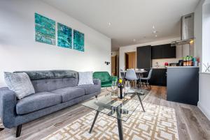 een woonkamer met een bank en een tafel bij Stylish Apartment Perfect for Business or Staycation in Birmingham