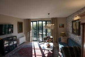 uma sala de estar com um sofá e uma mesa em Landhaus Storchennest - komfortable Appartements für 2-5 Personen em Reestow