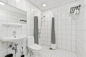 a white bathroom with a toilet and a sink at Ibsens Hotel in Copenhagen
