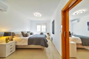 - une chambre blanche avec 2 lits et une fenêtre dans l'établissement Casa Jem, à Teulada