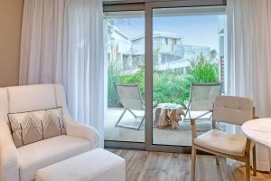 Domes Miramare, a Luxury Collection Resort, Corfu - Adults Only في مورايتيكا: غرفة معيشة مع كرسيين وطاولة