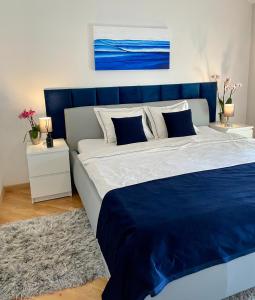 - un grand lit avec une tête de lit bleue dans une chambre dans l'établissement Apartments Corina, à Zagreb