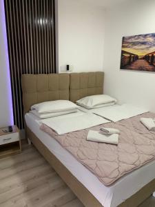 um quarto com uma cama grande e lençóis brancos em B&B Sandrina em Bilje
