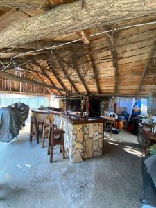Habitación con mesa y sillas bajo un techo de madera. en B&B Sandrina, en Bilje