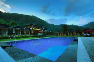 a large swimming pool in front of a resort at DLS MJ River Resort, Rishikesh in Shivpuri