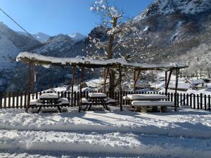 Dobres的住宿－Hotel Rural El Sestil，雪地中带长椅的凉亭