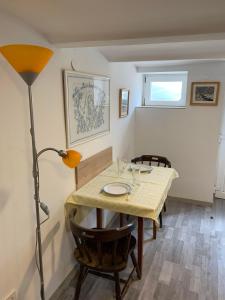 a dining room with a table and a lamp at Agapé Mini Stúdió in Balatonalmádi