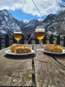 deux assiettes de nourriture et deux verres de bière sur une table dans l'établissement Hotel Rural El Sestil, à Dobres