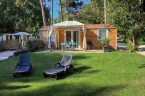 un cortile con 2 sedie e una tenda di Baia Dei Micenei a Otranto