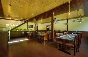 a dining room with tables and chairs and a staircase at DLS MJ River Resort, Rishikesh in Shivpuri