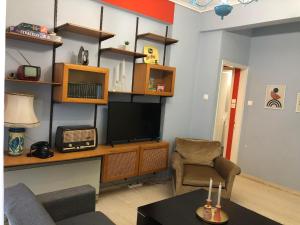 A television and/or entertainment centre at Olive - HappyHostGr - Downtown Apartment